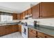 Functional kitchen featuring wood cabinets, a white range, and a window above the sink at 80 Squire Ct, Dunedin, FL 34698