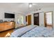 Comfortable main bedroom with hardwood floors, modern sliding barn door, and sun-filled French door access at 80 Squire Ct, Dunedin, FL 34698