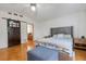 Inviting main bedroom featuring hardwood floors, barn door access, and natural light at 80 Squire Ct, Dunedin, FL 34698