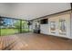 View of a screen patio featuring a ceiling fan, tv, and a view to a grassy lawn at 80 Squire Ct, Dunedin, FL 34698