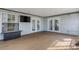 Covered patio featuring a flat screen television, white french doors, composite decking, and neutral tones at 80 Squire Ct, Dunedin, FL 34698