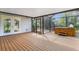 Spacious screened-in porch with outdoor hot tub, wood floors, and backyard views at 80 Squire Ct, Dunedin, FL 34698