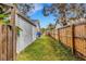 Side yard with a grassy area between a storage building and a wood fence at 80 Squire Ct, Dunedin, FL 34698