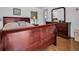 Bedroom with cherry toned furniture and wood look flooring in neutral tones at 807 Saint Charles Dr, Tarpon Springs, FL 34689