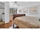 Bright bedroom with wood floors, slider to outside, ceiling fan and adjacent bathroom at 807 Saint Charles Dr, Tarpon Springs, FL 34689