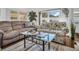 Cozy living room featuring comfortable sofas, a glass coffee table, and natural light at 807 Saint Charles Dr, Tarpon Springs, FL 34689