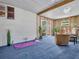 Bright sunroom featuring blue carpeting, light walls and ceiling, and neutral furnishings at 807 Saint Charles Dr, Tarpon Springs, FL 34689