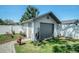 Detached one-car garage with gray door and white siding; complemented by landscaping and a fire hydrant at 8415 Westridge Dr, Tampa, FL 33615