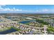 Expansive aerial view of a residential community featuring interconnected lakes and lush green spaces under a partly cloudy sky at 924 Peregrine Hill Pl, Ruskin, FL 33570