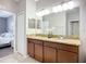 A bathroom with double sinks, granite countertop, and neutral tiled flooring is shown at 924 Peregrine Hill Pl, Ruskin, FL 33570
