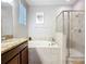 This bathroom features a soaking tub, glass shower, and vanity with granite countertops at 924 Peregrine Hill Pl, Ruskin, FL 33570