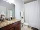 Bathroom featuring a vanity with granite countertop, white toilet, and shower with a white curtain at 924 Peregrine Hill Pl, Ruskin, FL 33570