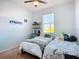 Bright bedroom featuring twin beds, a window, ceiling fan, and playful decor at 924 Peregrine Hill Pl, Ruskin, FL 33570