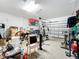 Spacious two-car garage with storage shelves, gym equipment, and visible clutter at 924 Peregrine Hill Pl, Ruskin, FL 33570