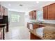 Well-lit kitchen featuring granite counters, tile flooring, and ample cabinet space at 924 Peregrine Hill Pl, Ruskin, FL 33570