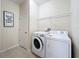 Functional laundry room with a washer, dryer, tiled floor, and framed decorative sign at 924 Peregrine Hill Pl, Ruskin, FL 33570