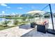 Covered patio featuring outdoor sectional sofa, patio table, umbrella, view of pond and white picket fence at 924 Peregrine Hill Pl, Ruskin, FL 33570
