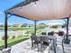 Backyard patio with dining under a pergola with string lights and views of pond at 924 Peregrine Hill Pl, Ruskin, FL 33570