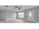 Bright living room featuring wood-look floors, a ceiling fan, and a large window for natural light at 9915 39Th N St # 3, Pinellas Park, FL 33782