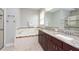 Elegant bathroom with a soaking tub, double sinks, granite countertops, and a glass-enclosed shower at 10428 Arbor Groves Pl, Riverview, FL 33578