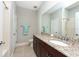 This bathroom features a granite-topped vanity, neutral tiling, and glass shower doors at 10428 Arbor Groves Pl, Riverview, FL 33578
