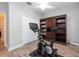 This exercise room shows stationary bike, built in bookcase, and white closet doors at 10428 Arbor Groves Pl, Riverview, FL 33578