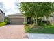 Charming home with a brick driveway, a well-manicured lawn, and mature trees enhancing its curb appeal at 10428 Arbor Groves Pl, Riverview, FL 33578