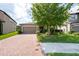 Inviting home with a brick driveway, lush landscaping, and a well-maintained exterior creating a welcoming atmosphere at 10428 Arbor Groves Pl, Riverview, FL 33578