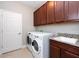 The laundry room exhibits a modern washer and dryer set and lots of cabinet space at 10428 Arbor Groves Pl, Riverview, FL 33578