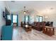Open-concept living room features wood-look floors, vaulted ceiling, and comfortable leather furniture at 10428 Arbor Groves Pl, Riverview, FL 33578