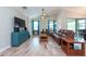 Stylish living room with wood floors, vaulted ceilings, ample seating, and a large TV at 10428 Arbor Groves Pl, Riverview, FL 33578