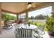 The screened lanai showcases comfortable seating and views of the fenced-in backyard at 10428 Arbor Groves Pl, Riverview, FL 33578