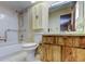 Bathroom featuring a bath tub, toilet, and single sink vanity with decorative wood doors at 11429 Nest Ct, Port Richey, FL 34668