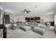 Open-concept living area with a large gray sectional, leading into the dining and kitchen areas at 11603 Fringetree Ct, Riverview, FL 33579