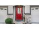 Charming red front door framed by stone accents and gray trim, flanked by two garage doors at 1208 Chatham Pine Pl, Brandon, FL 33511