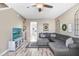 Cozy living room includes wood floors, a ceiling fan, and a comfortable gray sectional sofa at 1208 Chatham Pine Pl, Brandon, FL 33511