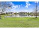 Scenic view of a community pond with lush green grass and apartment buildings in the background at 1208 Chatham Pine Pl, Brandon, FL 33511