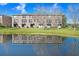 Rear view of townhomes overlooking a pond, featuring sliding glass doors and a well-manicured lawn at 1208 Chatham Pine Pl, Brandon, FL 33511