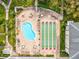 Community pool, shuffleboard, walkways and landscaping with mature trees and multiple buildings are featured in this aerial view at 1235 S Highland Ave # 1-204, Clearwater, FL 33756