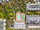 Aerial view of the community pool, shuffleboard, walkways and landscaping with mature trees and multiple buildings at 1235 S Highland Ave # 1-204, Clearwater, FL 33756