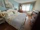 Cozy bedroom featuring a floral patterned bed, wooden dresser, and natural light from the window at 1235 S Highland Ave # 1-204, Clearwater, FL 33756