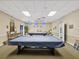 This game room features three pool tables with blue accents, billiard accessories and comfortable seating at 1235 S Highland Ave # 1-204, Clearwater, FL 33756