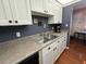 Kitchen featuring stainless steel sink, white cabinets, and a stylish countertop with a decorative backsplash at 1235 S Highland Ave # 1-204, Clearwater, FL 33756
