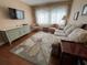 Bright living room with hardwood floors, light-filled window views, floral sofa and rug, and green bureau at 1235 S Highland Ave # 1-204, Clearwater, FL 33756