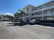 Parking lot view with a parked gray sedan showcasing ample parking and a well-maintained building in the background at 1235 S Highland Ave # 1-204, Clearwater, FL 33756
