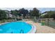 Relaxing community pool and lounge area with mature trees and plants for shade and privacy at 1235 S Highland Ave # 1-204, Clearwater, FL 33756