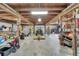 Barn interior featuring exposed wooden beams, a tractor, and ample storage at 13607 Mcintosh Rd, Thonotosassa, FL 33592