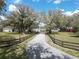 Scenic driveway leading to the property, framed by a wooden fence and lush greenery at 13607 Mcintosh Rd, Thonotosassa, FL 33592