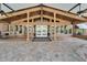 Covered patio with brick pavers, white pillars, and large windows that offer view into the interior of the home at 13607 Mcintosh Rd, Thonotosassa, FL 33592