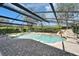 Relax in this backyard pool with a waterfall feature and a lush, green backdrop, all set in a screened enclosure at 13607 Mcintosh Rd, Thonotosassa, FL 33592